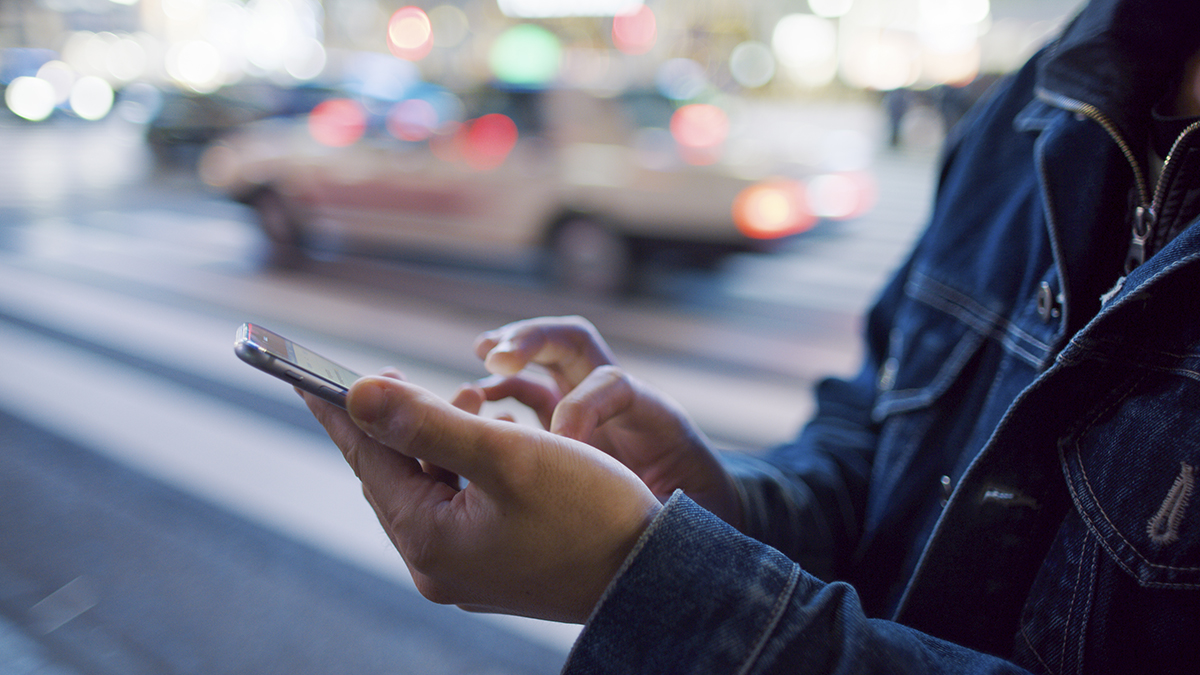 A man uses a mobile phone at Shibuya crossing